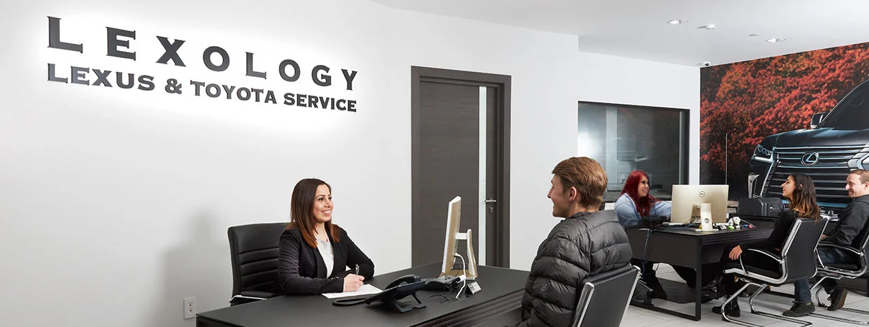 Customer at front desk speaking with receptionist at Lexus and Toyota service center